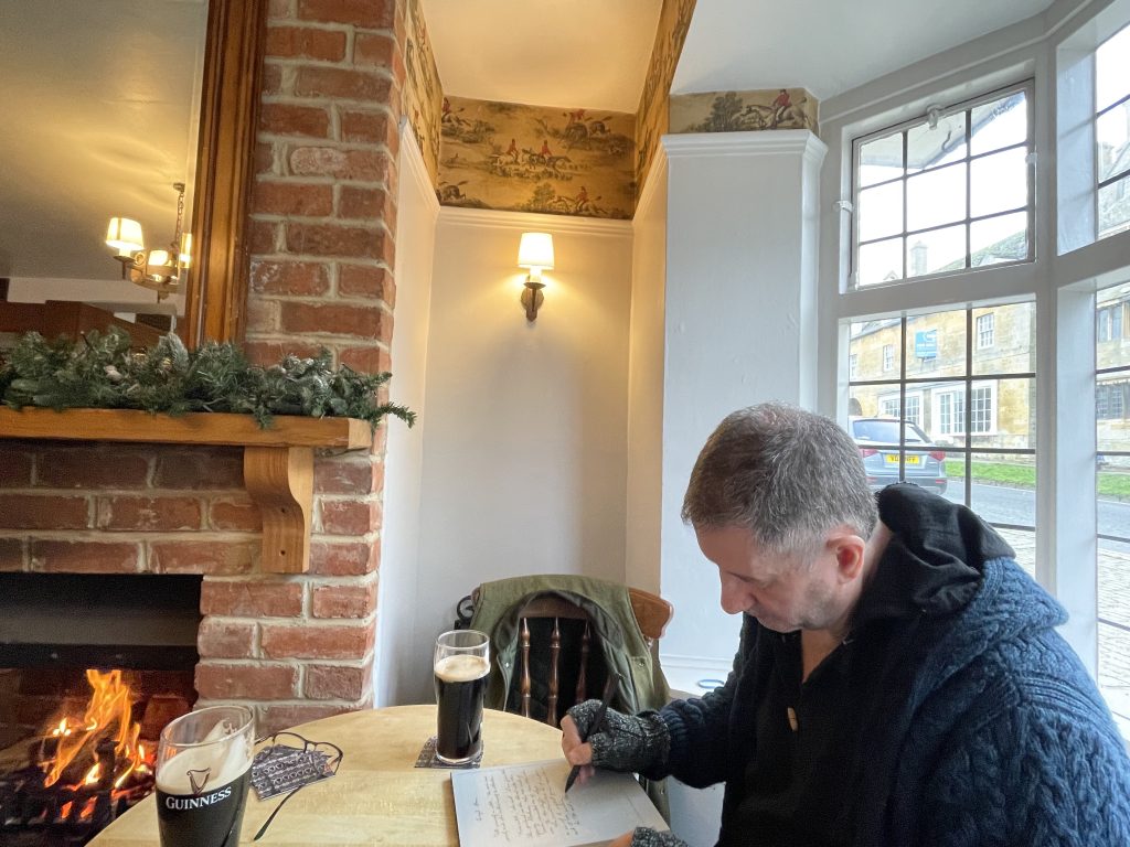 Dr. Gerard Collins writing by the cozy fireside at the Horse and Hound